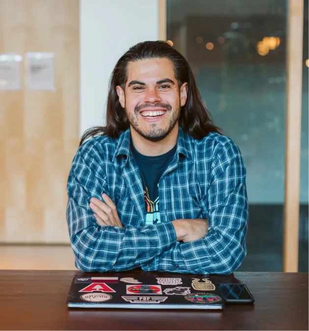 Man with closed laptop and crossed arms smiling