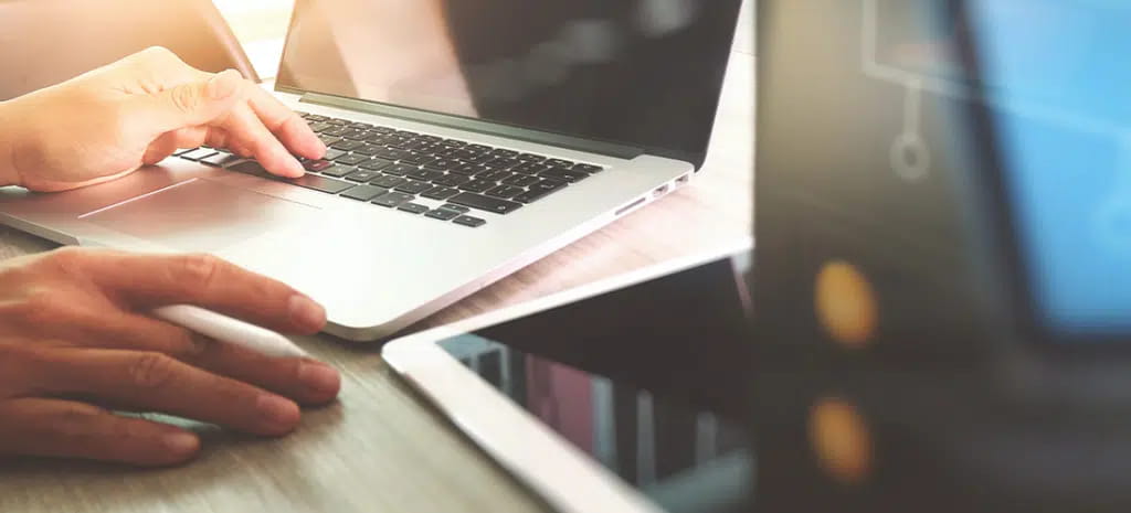 Website designer working with a digital tablet and laptop computer with design diagram on wooden desk and compact server. How To Change Your WordPress Website's Domain Name